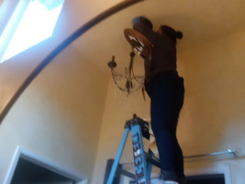 Electrician installing a chandelier in a Dayton residence